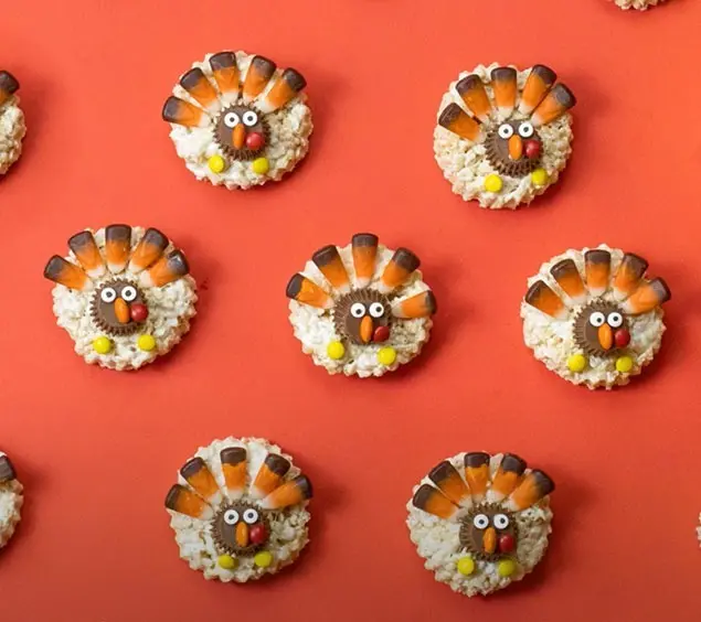 Turkey shaped rice crispy treats sit on an orange background.