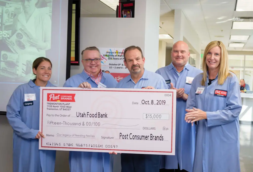 Group standing behind donation check