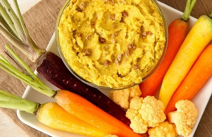 Curried hummus with colorful carrots and cauliflower