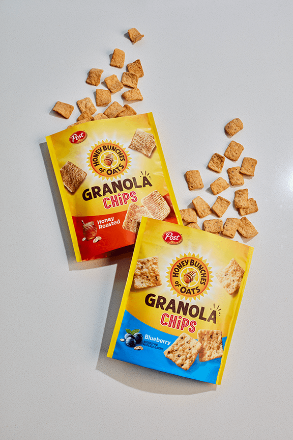 Honey Bunches of Oats Granola chips come out the top of two bags.