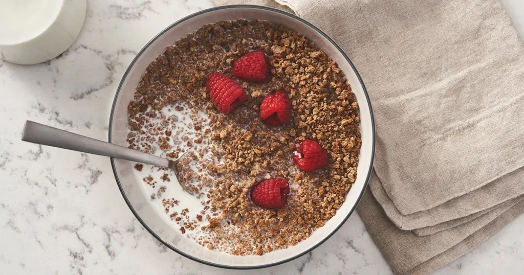 A bowl of Grape-Nuts with raspberries.