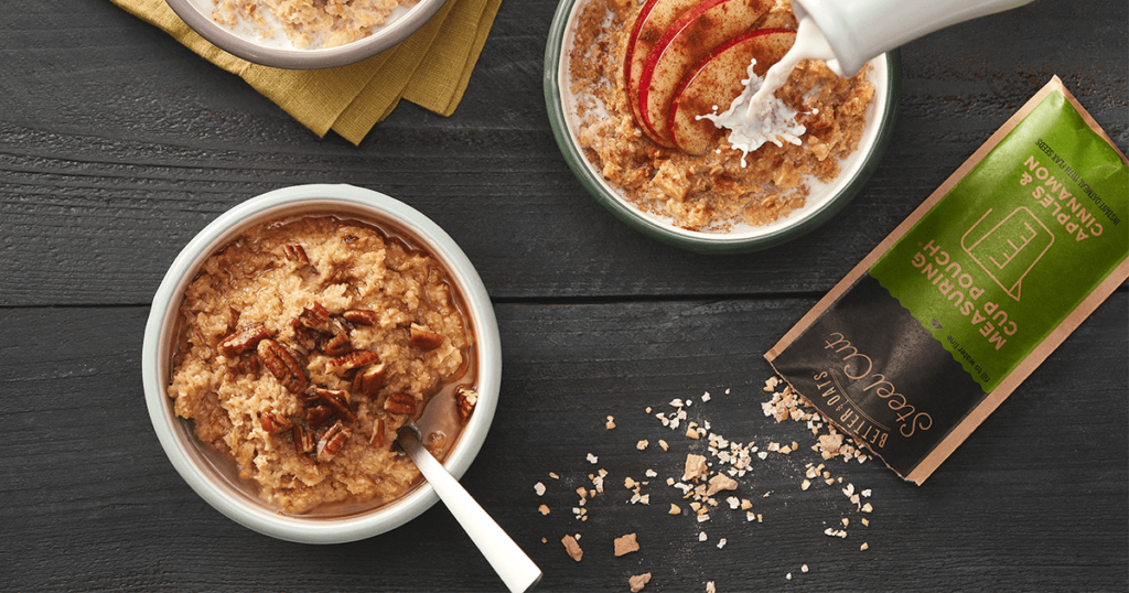 A bowl of Better Oats Steel Cut Instant Oatmeal Apples & Cinnamon topped with pecans and a packet of the product