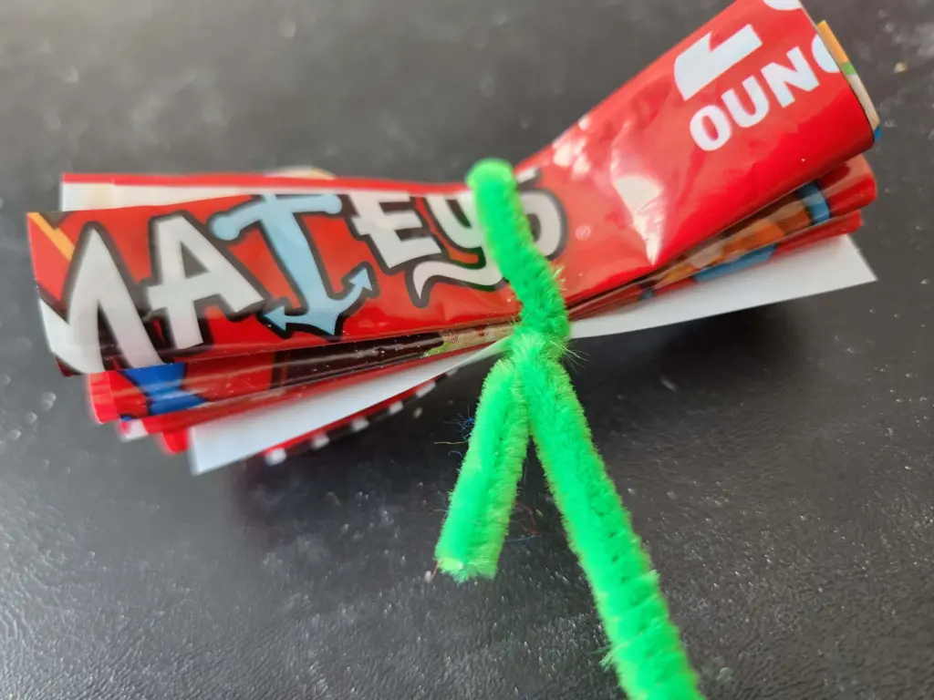 cardboard cutout of flower secured with pipe cleaner
