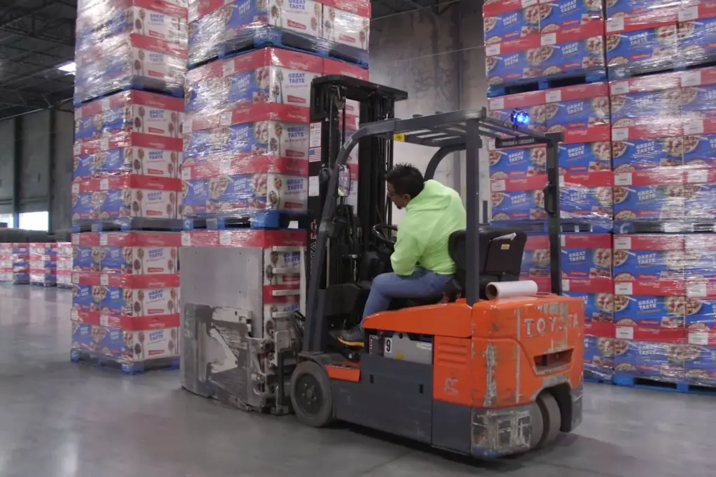 Man driving forklift in warehouse