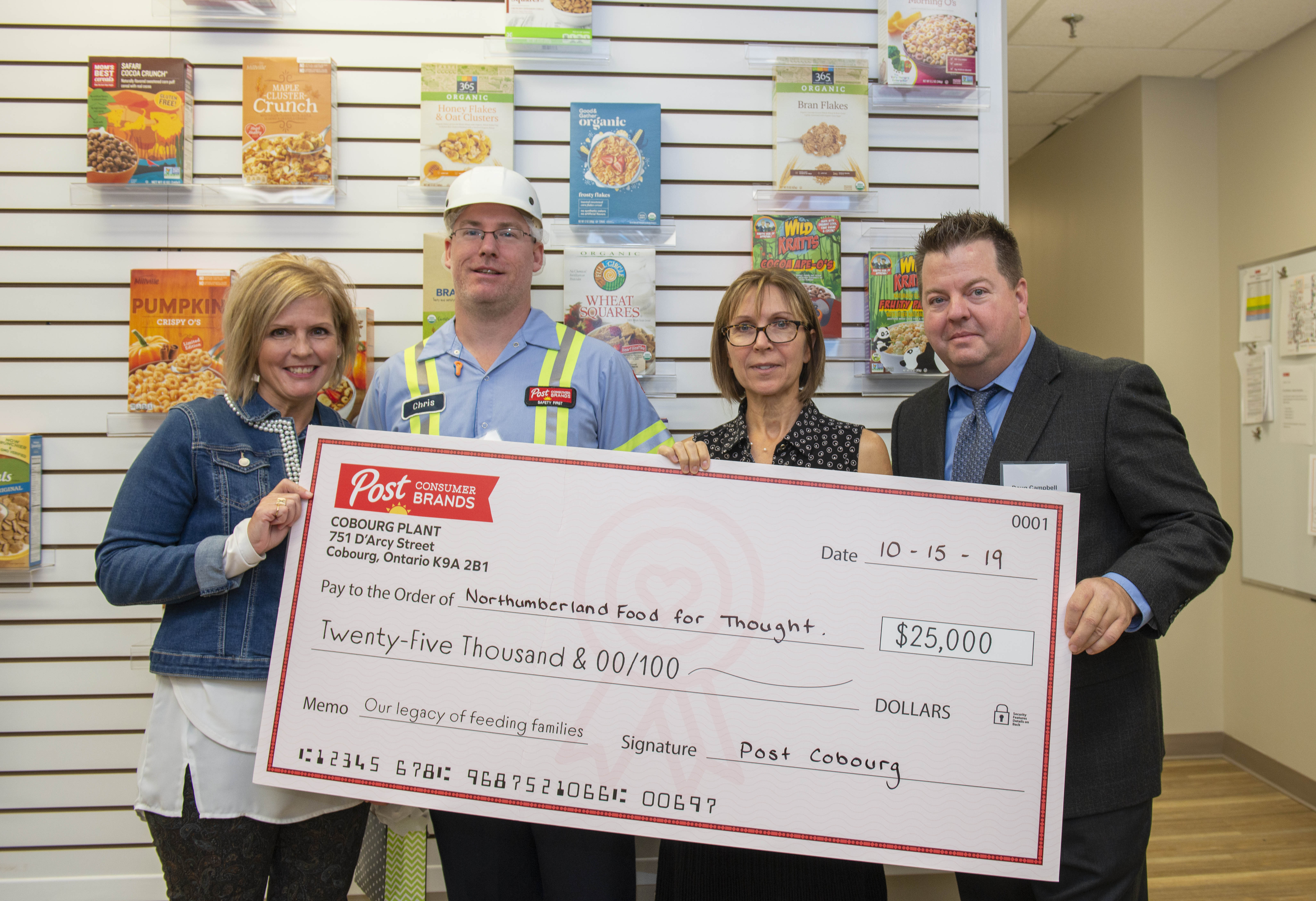 Four people standing with over-sized donation check