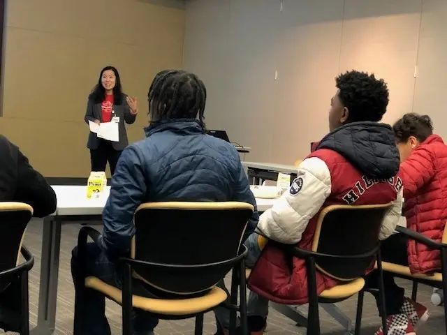 Students in a classroom listening to a speaker