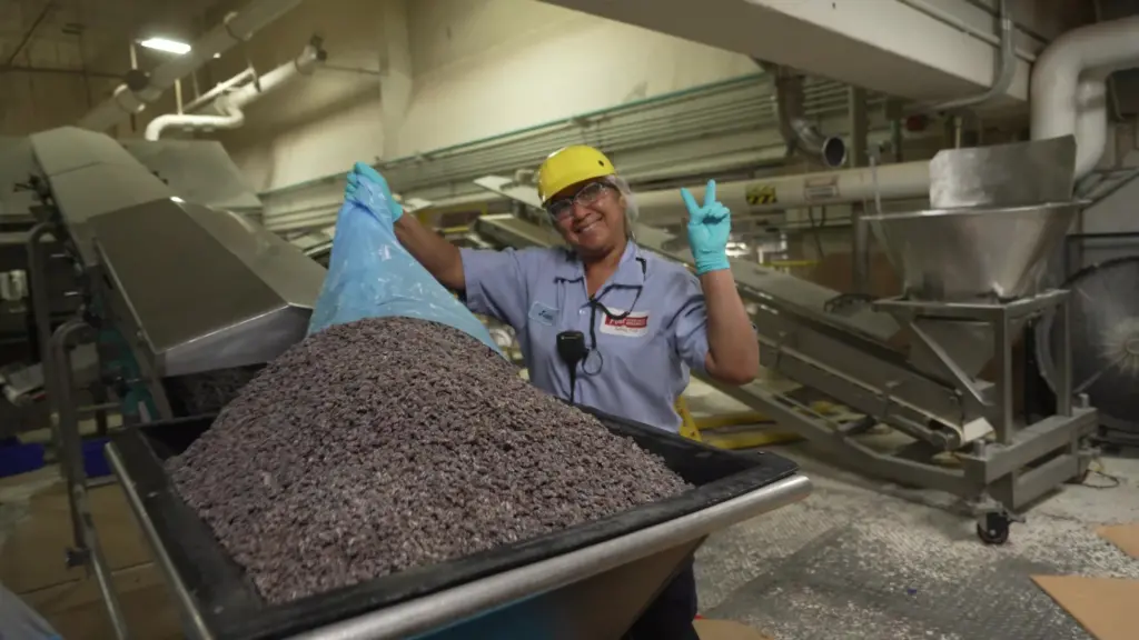 A Post employee poses for a photo next to a large container of cereal