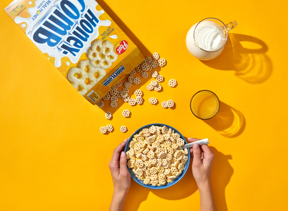 A bowl of Honeycombs next to a box of Honeycombs