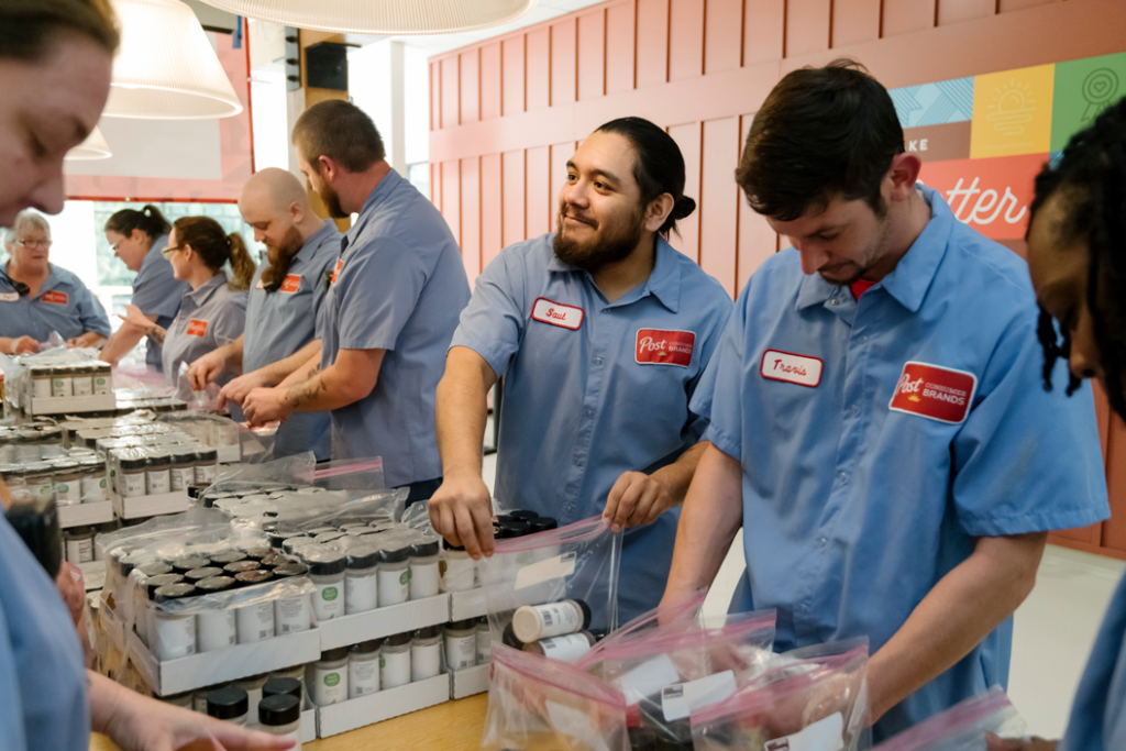 Post employees work together to package food for the less fortunate