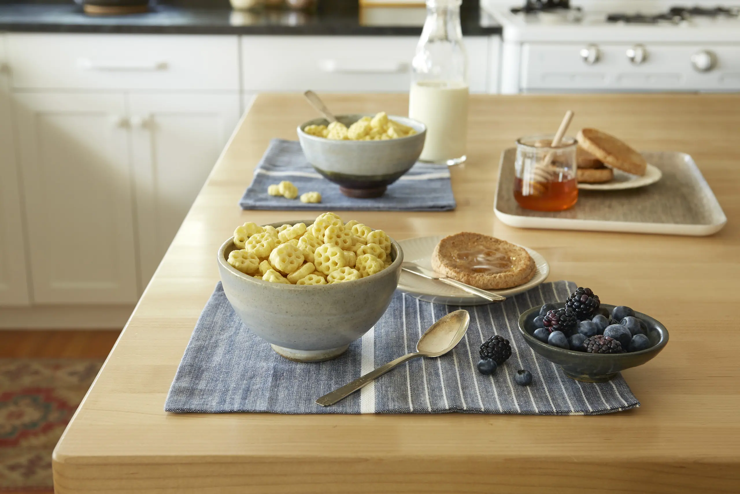 Honeycomb cereal in a bowl served with fruit and an english muffin