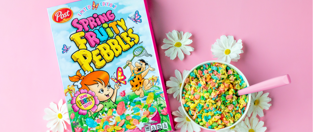 A box of Spring Fruity PEBBLES and a bowl of Spring Fruity PEBBLES cereal surrounded by daisies