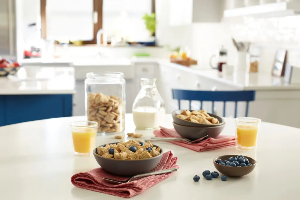 Spoon Size Shredded Wheat cereal with blueberries in a bowl as part of a breakfast table spread