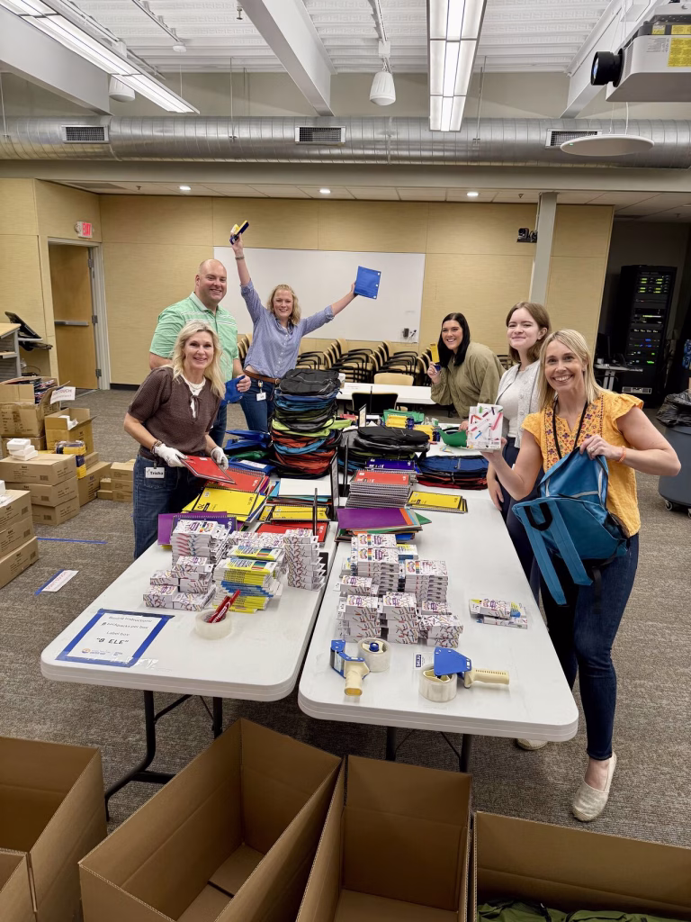 Employees packing backpacks for the 25-26 school year.
